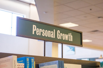 A genre sign in a book store labeled Personal Growth