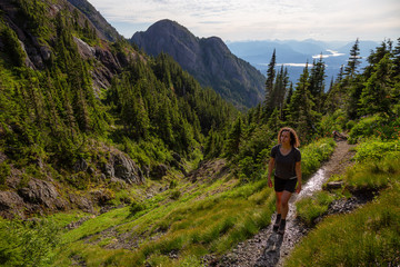 Adventurous girl hiking the beautiful trail in the Canadian Mountain Landscape during a vibrant...