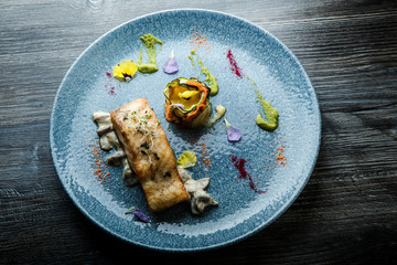 top view on roasted fish steak served on fried mushrooms