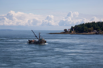 Obraz premium Fishing boat riding against the current in the narrows near Gulf Islands, Vancouver Island, British Columbia, Canada, during a sunny summer day.