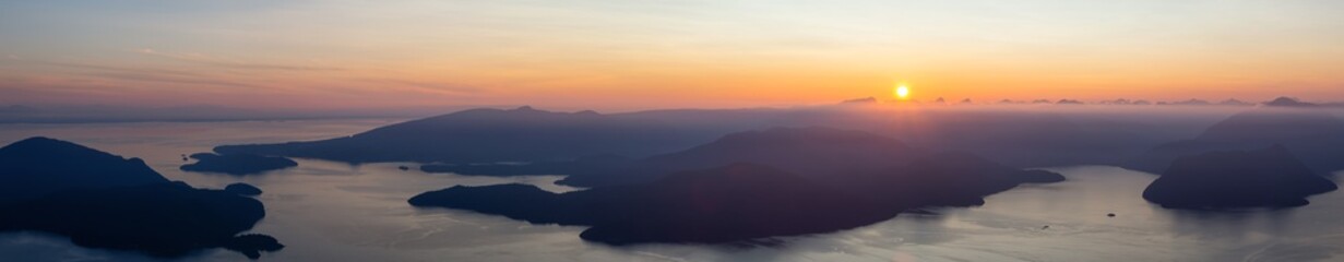 Beautiful Panoramic View of Canadian Mountain Landscape covered in clouds during a vibrant summer sunset. Taken on top of St Mark's Summit, West Vancouver, British Columbia, Canada.