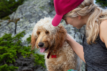 Adventurous Blonde Caucasian Woman Hiker is spending time with her Dog in the nature. Taken in West Vancouver, British Columbia, Canada.