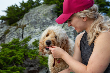 Adventurous Blonde Caucasian Woman Hiker is spending time with her Dog in the nature. Taken in West Vancouver, British Columbia, Canada.