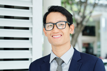 Fototapeta premium Portrait of happy young Asian entrepreneur with beautiful toothy smile looking at camera