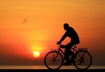Fototapeta na wymiar Silhouette Cycling on blurry sunrise sky background.