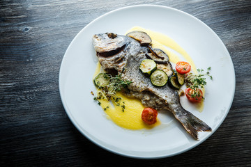 top view on tasty fish served with sliced baked vegetables