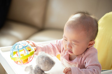 Asian baby happy in the room.Asian baby girl lying down on bed .Baby read book and play toy.