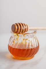 Close-up view of jar of honey on stone table.
