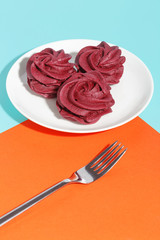 Dietary dessert, pink marshmallows on a white plate.