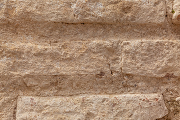 The texture of the surface of natural stone, close-up. Building material of ancient civilizations. Background. Spaces for text.