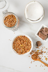 Overhead view of bowl with granola with coconuts and chocolate