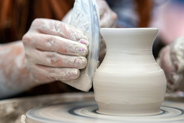 Fototapeta na wymiar Potter makes pottery dishes on potter's wheel