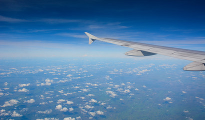 Wing of an airplane flying above the clouds