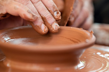 Potter makes pottery dishes on potter's wheel