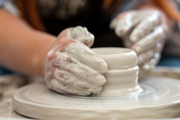 Potter makes pottery dishes on potter's wheel
