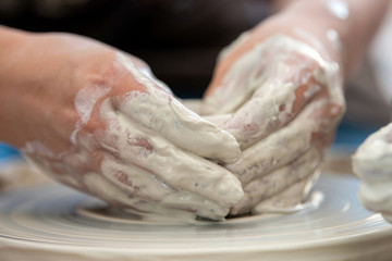 Potter makes pottery dishes on potter's wheel