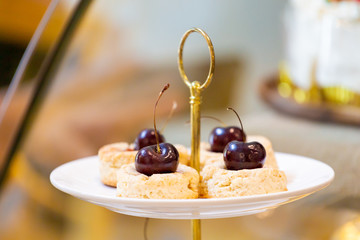 Vanilla cookie cake with topping cherry in coffee cafe