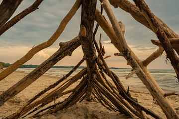 sunset at Sandbanks Beach Picton Ontario Canada with nice sun, clouds, branches, lake view, sand, and light.