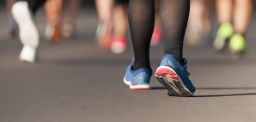 Runners feet running on road close up on shoe