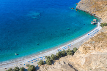 Aerial view of Glyka Nera beach (Sweet Water or Fresh Water). View of the remote and famous Sweet Water Beach in south Crete, with its unique tavern on the rock inside sea. This is a nudist beach.
