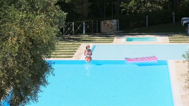 Beautiful young woman relaxing in swimming pool.
