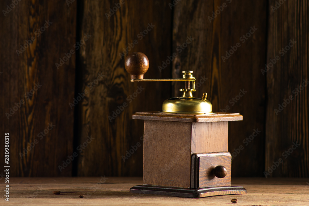 Wall mural antique coffee grinder and three grains of coffee on a wooden table