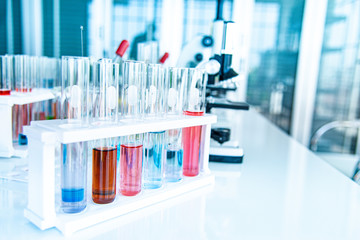 Preparing Laboratory equipments such as glassware, tube with blue and liquid on the white table. The chemistry experiment in scientific research
