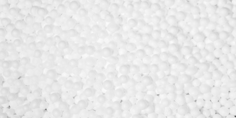 white polystyrene foam beads ball drop from Styrofoam machine for fragile stuff packaging box, plastic texture background decoration