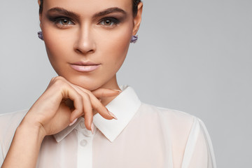 Portrait of a beautiful pacified woman in a white shirt. Studio photo session