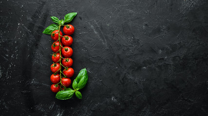 Fresh cherry tomatoes on a black background. Top view. Free space for your text.