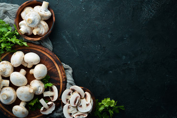 Mushrooms sliced on a black table surface. Top view. Free space for text.
