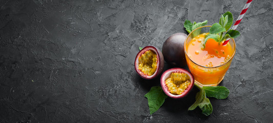Passion fruits juice and fruit on a black background. Tropical Fruits. Top view. Free space for...