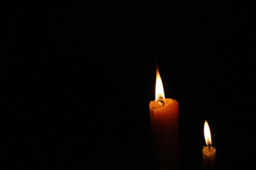 Soft-focused dramatic burning candle lights at night