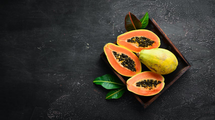Papaya fruit on a wooden background. Tropical Fruits. Top view. Free space for text.