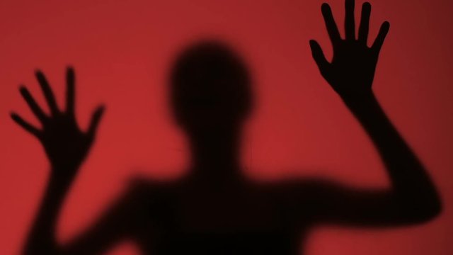 Female silhouette trying to find way in panic, danger of fire, frightened victim