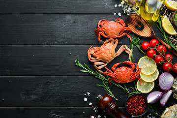 Cooked crabs with spices on a black background. Top view. Free space for your text.