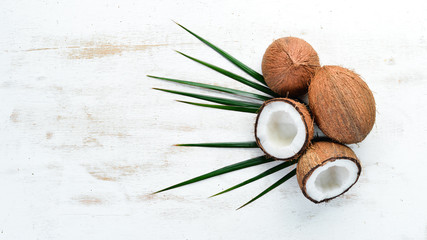 Fototapeta na wymiar Fresh coconut on a white wooden background. Tropical Fruits. Nut. Top view. Free space for your text.