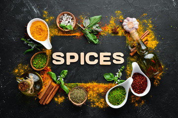 Indian spices on a black stone background. The word "spice" Indian spices. Top view. © Yaruniv-Studio