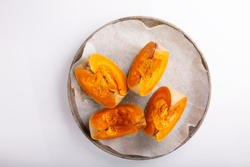 Pumpkin slices baked in the oven. Roasted pumpkin pieces on a baking tray. Healthy, vegan or vegetarian food.
