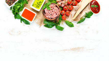 Preparing Bolognese sauce. On a white wooden background. Top view. Free space for your text.