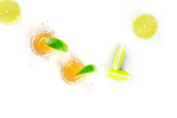 Golden tequila with lime slices on a white background, top shot with a place for text