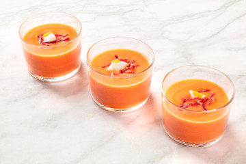 Salmorejo, Spanish cold tomato soup, in glasses on a white marble background with copy space
