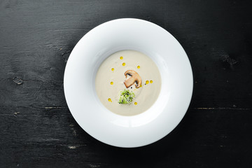 Cream soup of mushrooms. On a wooden background. Top view. Free space for your text.