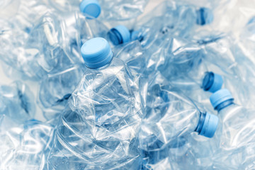 stack of compressed plastic bottles with blue caps