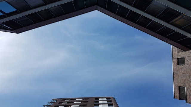 Blauer Himmel zwischen blauen Gebäuden