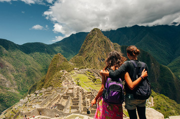 Couple looking at the Lost city of the Incas, Machu Picchu, Peru - obrazy, fototapety, plakaty
