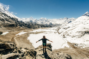 Landscape with girl, high mountains with snowy peaks, path, blue sky in Nepal. Travel. Vintage style. Nature