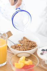 シリアルに牛乳をかける女性の手元