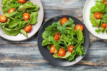 Vegetables salad in a plate on a wooden background.  Top view