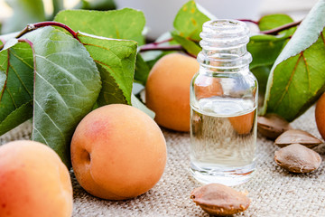 Apricot flavor oil and fresh apricots on a wooden table.
